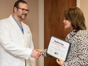 Janet Thompson from PAMED Society hands Dr. Victor Pilewski an award.