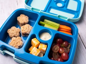 Bento box lunch with cheese, fruit, and vegetables