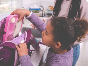 Tips for Healthy Back-to-School Lunches 3 Girl packing bento box lunch into bookbag