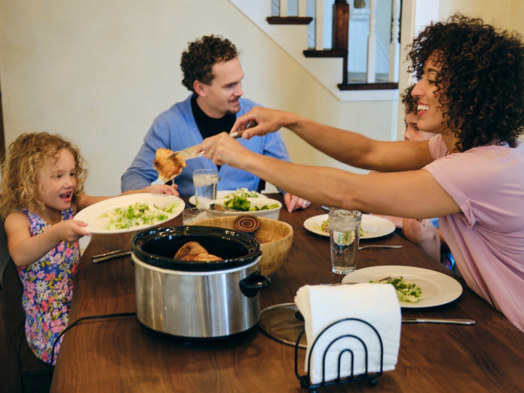 Family with crockpot at dinner table