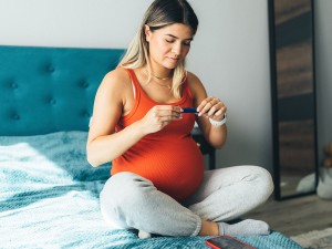 Pregnant woman possibly checking blood glucose