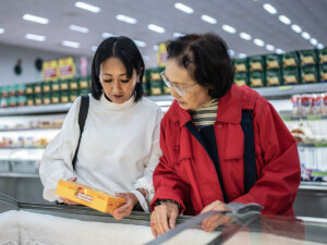 Two women reading food label on a frozen food package