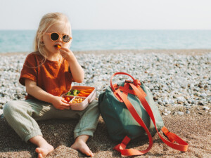Girl on beach with veggie container