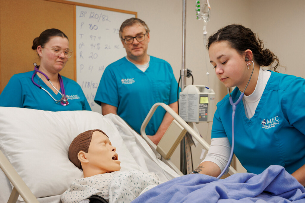 Home 9 Three students from the Institute for Healthcare Professional's Practical Nursing Program practice patient care on a dummy.