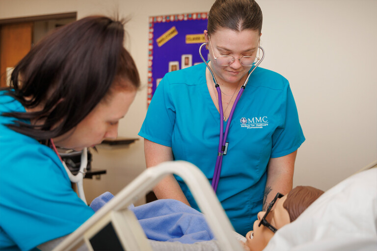 Students from the Institute for Healthcare Professional's Practical Nursing Program practice patient care on a dummy.