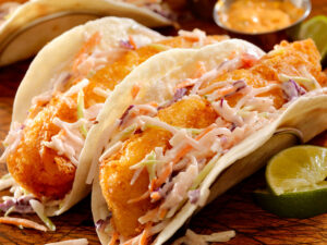 How the MIND Diet Promotes a Healthy Brain 3 A closeup of fish tacos topped with slaw.