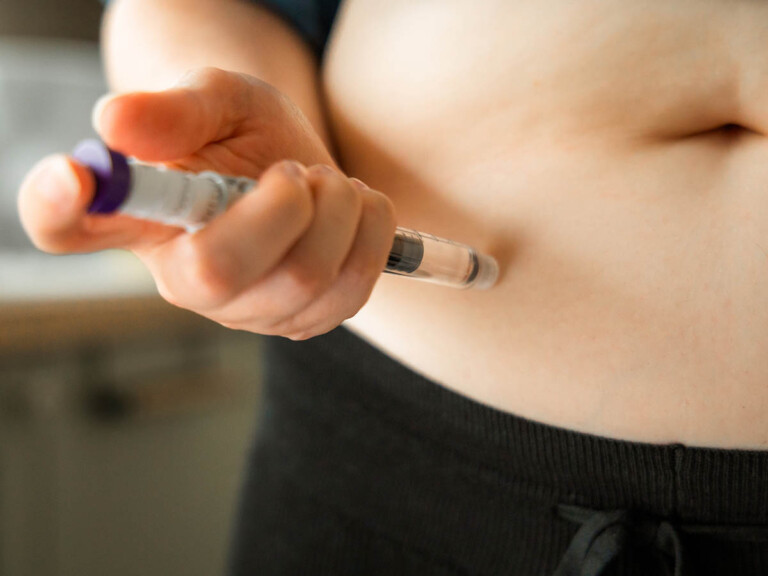 Close-up of Woman injecting GLP-1 medication into her abdomen.