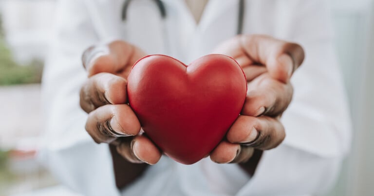 A doctor holding a heart prop in his hands