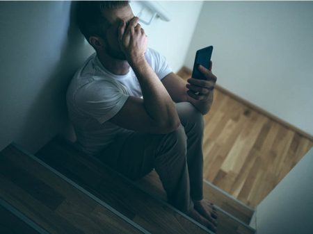 Distraught Person Holding Mobile Phone