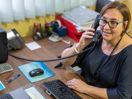 Kind woman talking on phone, possibly a worker on a warmline.